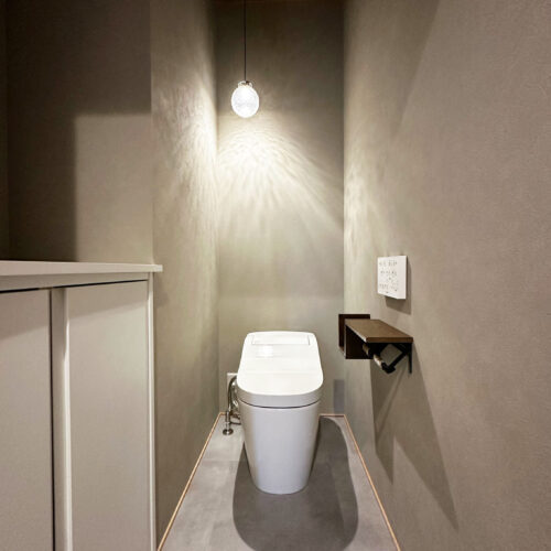 1階トイレはグレーを基調にした落ち着きのある空間。照明がつくるやさしい陰影が、上質な雰囲気を演出してくれます。