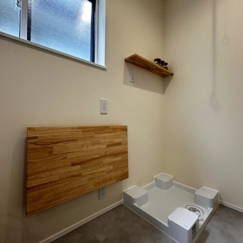 洗面横のサンルームには、使わない時は壁際にすっきり収まる、折り畳み式の造作カウンターを設けました。洗濯物を畳んだり、アイロンがけをしたりと、家事スペースとして便利に活躍します。
